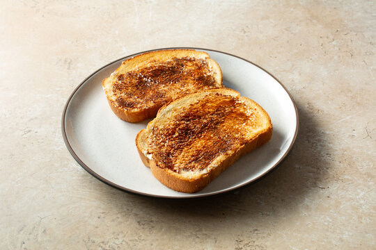 A view of some vegemite toast, on a plate.