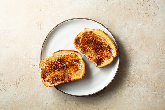 A top down view of some vegemite toast, on a plate.