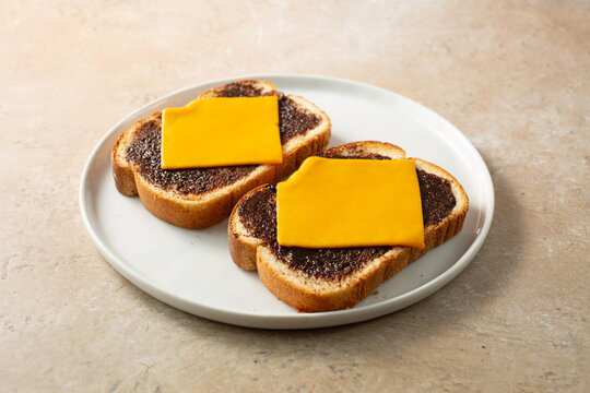 A view of vegemite cheese toast, on a plate.
