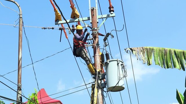 Electrical technicians with complete PPE are working on tightening the cable stretch under the 20 kV electrical voltage network