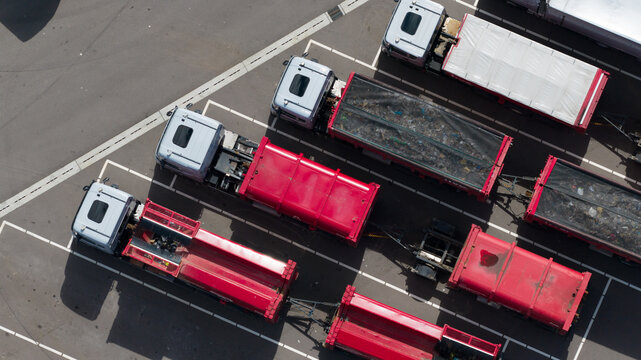Alkmaar, Noord-Holland, Netherlands - 09 June 2026: Aerial view of red waste collection trucks parked at the HVC waste-to-energy facility, showing industrial waste management operations.