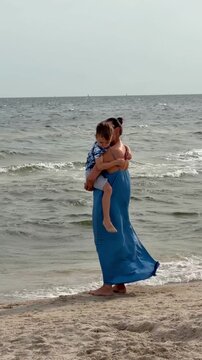 A woman holding a boy against the backdrop of the Baltic Sea, Poland