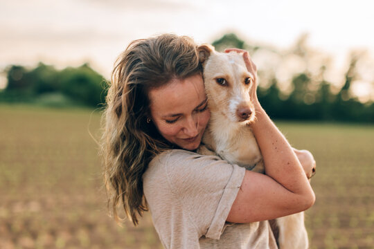 Woman hugging dog showcasing love and companionship in field