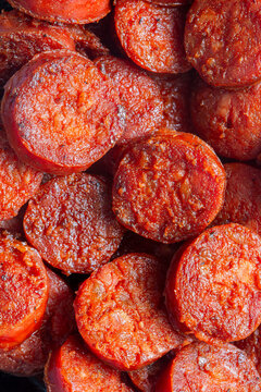 Spicy traditional sliced fried Spanish chorizo sausage background backdrop. Traditional Spanish food concept.