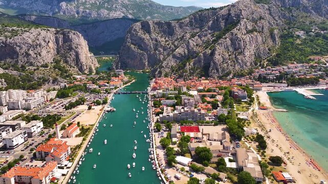 Omis Croatia overview with river, boats, buildings, mountains, and beach shoreline