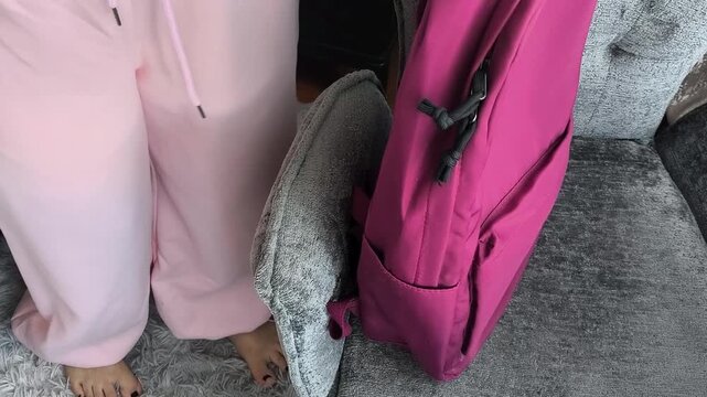 A female student takes a school backpack from a chair in the bedroom and leaves. preparation for school, the beginning of the school day