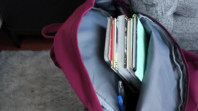 Backpack with books and school supplies on chair, preparing for school or university, student life and education concept.