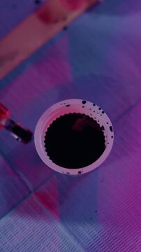 Tattoo, ink cap and hands of person in parlor to prepare for artwork, design and body modification. Shop, aesthetic and artist with machine, pigment and tools for permanent art, service and start