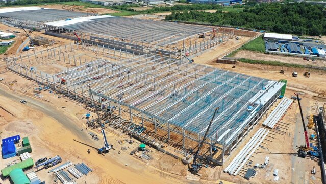 Industrial Construction Site: An expansive view of a large-scale industrial construction project, showcasing the intricate steel framework of multiple buildings under development.