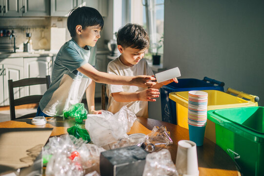 Family sorting plastic waste for recycling in the kitchen