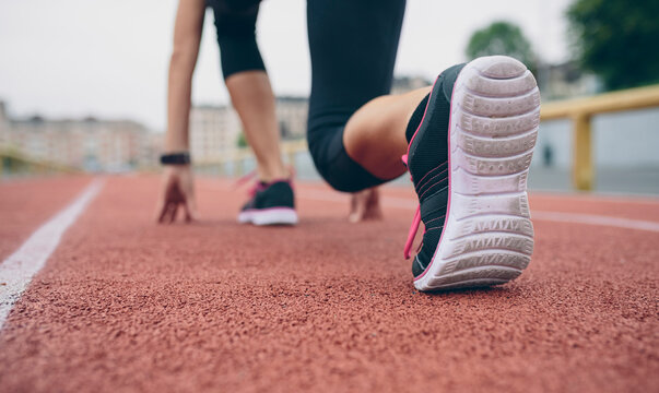 Woman on tartan track in starting position