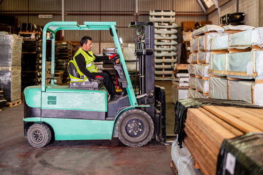 Worker operating forklift at warehouse