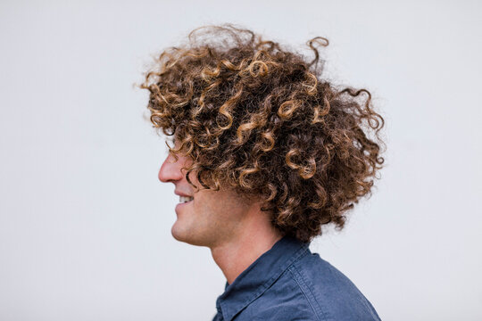 Profile of smiling man with curly hair