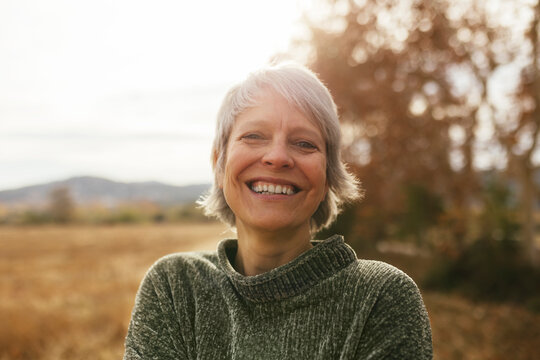 Happy woman with gray hair at field