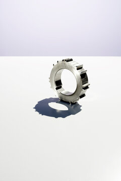 Broken metal gear with a missing tooth on a white background