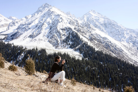 Photographer exploring and taking photos in a snowy mountain range