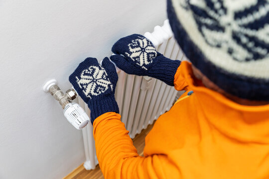 Senior man standing with hands on radiator