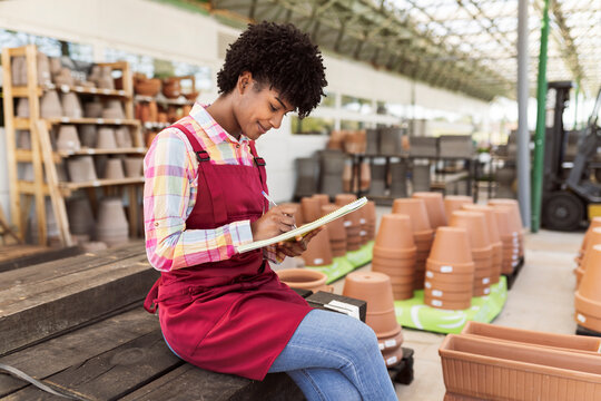 Young gardener preparing inventory sitting in warehouse