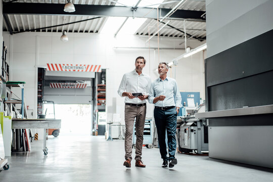 Male engineers looking away while walking in factory