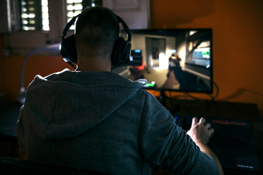 Young man sitting at his PC, playing computer games