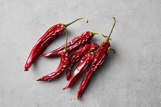Dried red chili pepper on a grey textured surface