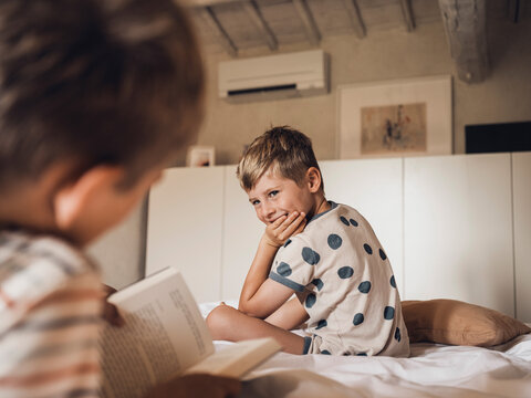 Friends reading a book in a bedroom in Tuscany