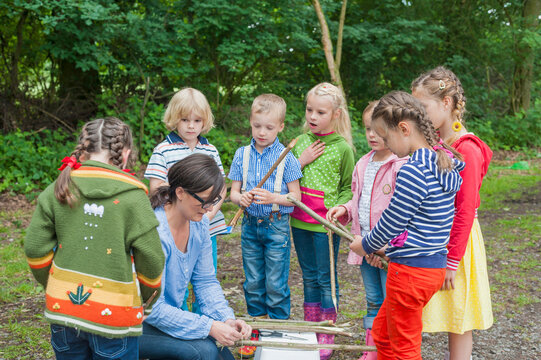 Germany, Children learning how to build a wooden raft
