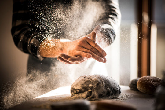 Man preparing black burger buns in kitchen