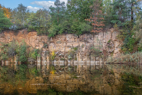 Sandstone quarry cliff reflection in lake water serene nature landscape scenery with calm mood