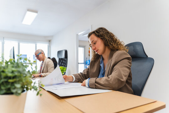 Businesswoman with disability reading paperwork in inclusive office