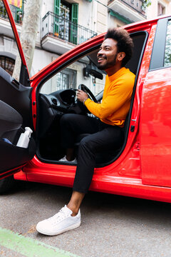 Happy Afro man disembarking from car
