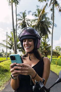 Tourist with helmet using smartphone in Bali Indonesia