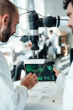 Scientist evaluating medical graphics on tablet in laboratory