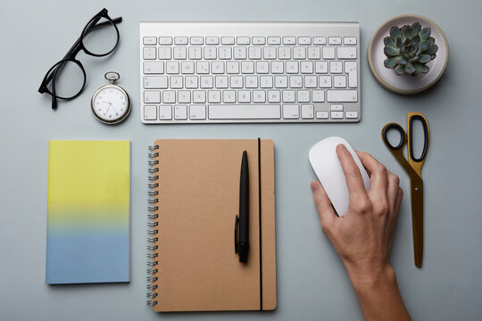 Top view of woman using computer mouse on desk