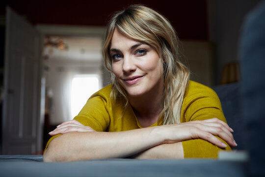 Portrait of smiling woman relaxing on the couch at home