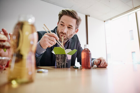 Businessman having lunch break with asian food