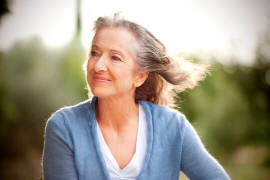 Portrait of smiling woman with blowing hair in the garden