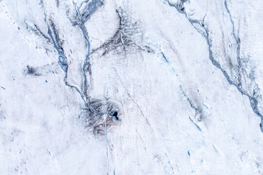 Aerial view of a melting glacier moulin and volcanic ash in Iceland