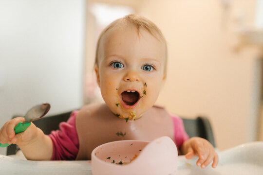 Messy eating with spoon during baby led weaning indoors