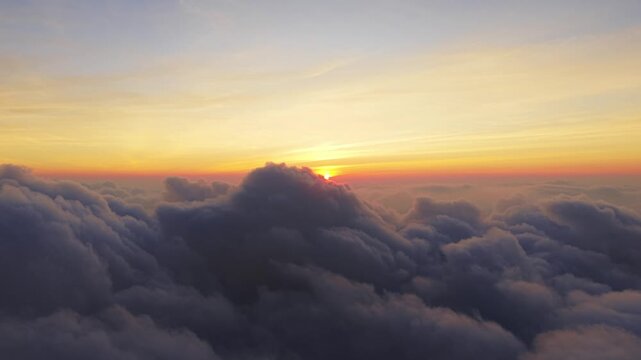 Aerial view of sunrise over the clouds with Mount Sindoro and Mount Sumbing in the distance in Kecamatan Kedu, Jawa Tengah, Indonesia.