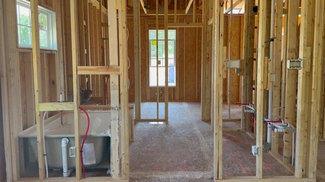 Inside of an unfinished custom built home during the structural skeleton stage highlighting high-quality craftsmanship. Perfect for subcontractor inspection and property development projects.