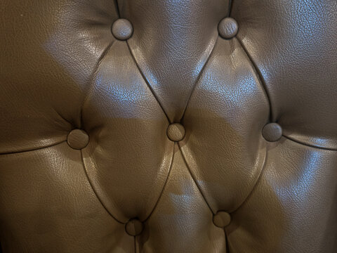 tufted leather upholstery surface featuring buttoned structure and natural grain texture. Ideal for luxury interior design concepts, furniture background materials, and premium texture composition use