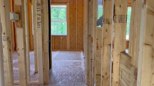 Trucking shot to the left revealing the interior of a new residential house under construction. Perfect for home build or renovation projects.