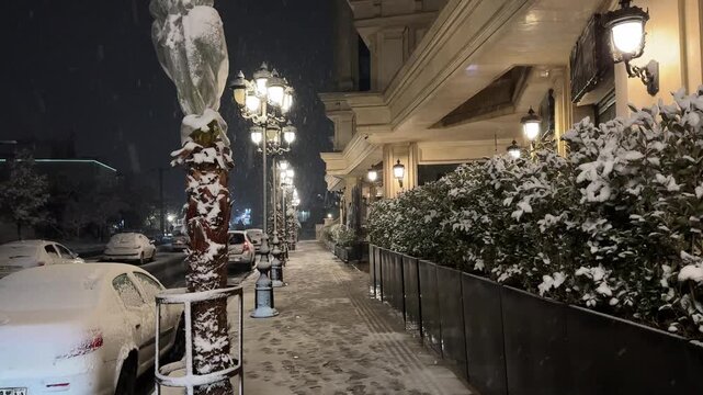 Antique vintage street light lantern with warm glowing amber color night winter snow covered palm cafe exterior decorative cozy elegant Tehran Iran empty traditional architecture sidewalk Paris mood