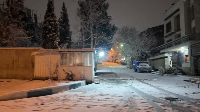 Tehran Iran winter night snowfall at a security gate checkpoint barrier residential neighborhood luxury district urban street illuminated surveillance protection entrance gate cold downtown landscape