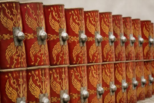 A repeating pattern of Roman shields forming a defensive wall.