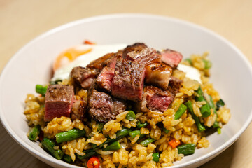 Fototapeta premium Close-up view of steak cube on top of fried rice.