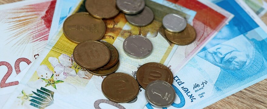 Israeli shekel money bills and coins on table. Israel cash of ILS currency close up