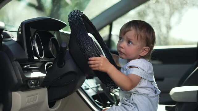 Funny child playing in car. Toddler enjoys playful moment vehicle. Curious child explores car interior. Happy funny moments with child. Toddler amusing playtime in car. Child joyful funny adventure.
