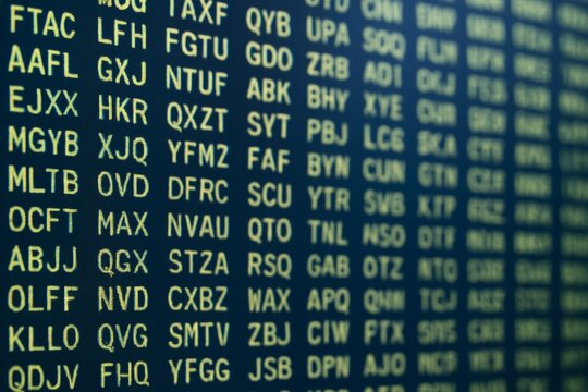Digital airport-style display with glowing yellow alphanumeric codes on dark blue background, concept of travel and technology communication screen. Ai generative